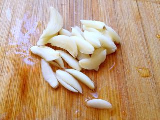 3、炒五花肉,大蒜切片。