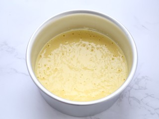 7、山药鸡蛋糕,剪一张和模具直径差不多大小的圆形油纸,铺到模具的底部,然后倒入打好的鸡蛋山药糊,轻震几下震出气泡