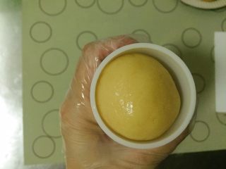 12、金沙奶黄月饼,将月饼搓圆，表面滚薄薄的玉米淀粉或者熟面粉后放到月饼模具中，放在烤盘中压出清晰花纹