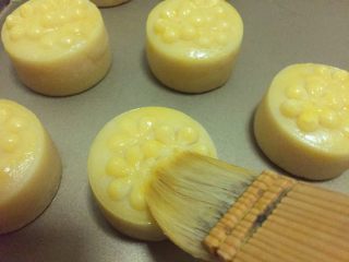 14、金沙奶黄月饼,待花纹定型后，取出来刷一层薄薄的蛋黄液，接着烤15分钟，最好中间再取出来刷一次蛋黄液