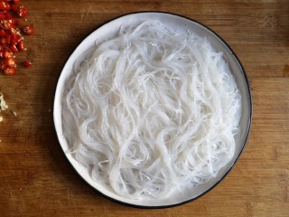 6、蒜蓉粉丝蒸金针菇——快手下饭就靠它,将泡好的粉丝平铺在盘中。