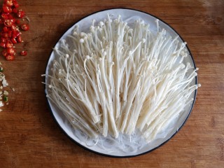 7、蒜蓉粉丝蒸金针菇——快手下饭就靠它,将洗净的金针菇切根，撕开铺在粉丝上。