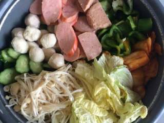 9、自制【韩式部队火锅】,用韩式辣酱把白菜帮炒熟，然后 在锅中码放好所有材料，加入水， 没过所有食材，等水开后加入浓汤 宝跟韩式辣酱，加入适量盐，小火煮几分钟就好 了。香香辣辣很好吃!