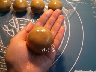 22、【斑纹豆沙莲蓉月饼】自制红豆沙+白莲蓉,用手把饼皮沿着馅料慢慢推开推薄，全部包裹住以后再搓圆搓均匀