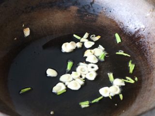 6、土豆豆角焖面,锅内放适量的色拉油，放入大蒜炒香；