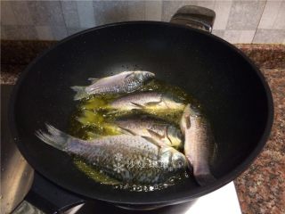 3、酸菜烧鲫鱼,放入鲫鱼炸至表皮焦黄。