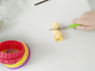 10、浪漫七夕胡萝卜玫瑰馍,卷好后，用刀子，在中间切开。