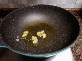 6、韭黄炒虾仁,放入生姜片翻炒出香味。