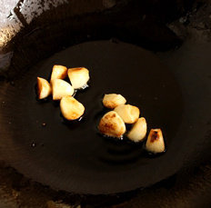 2、腐竹焖羊腩,锅里放入2匙油,小火把蒜头煎至金黄后连油带蒜头装起备用