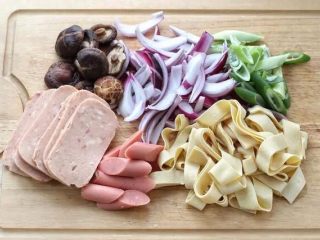 2、部队火锅,干香菇泡发后在上面划十字，洋葱、大葱、午餐肉、火腿肠和干豆腐如图中切好。