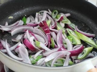 4、部队火锅,锅中倒少许食用油烧热，放入洋葱和大葱小火炒出香味。