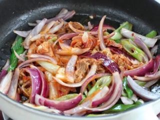 5、部队火锅,接着放入辣白菜继续翻炒一两分钟，辣白菜里最好带些汤汁。