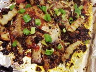 7、烤鲳鱼,最后拿出洒上芹菜段和大葱白段烤5分钟后取出洒上大葱叶段或香菜既可。