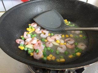 9、三鲜小米锅巴,加入焯水后的杂蔬翻炒均匀后加适量的清水