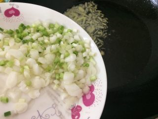 5、葱姜油,在姜丝微收干的时候我们倒入葱白的部分