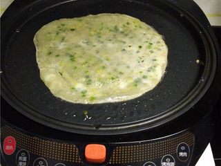 12、快手葱油饼,电饼铛刷油，放入饺子皮；启动“煎饼”程序；