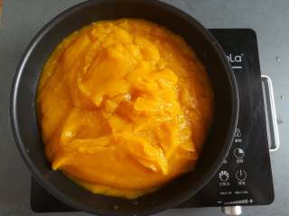 8、金沙南瓜馅,全部的南瓜泥放入炒锅里小火慢慢炒