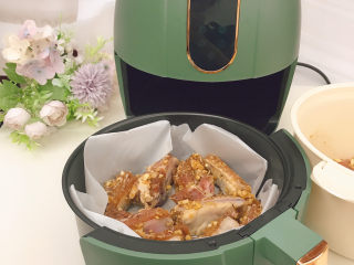 13、蒜香烤排骨,空气炸锅中放上油纸，将排骨平铺在上面