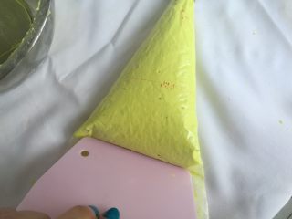8、春色马卡龙,裱花袋装入中号圆形裱花嘴，装入裱花袋，用刮板推至裱花嘴处。