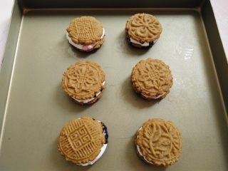 14、棉花糖淋酱饼干,趁热把另外一块饼干花纹朝上，盖在淋了巧克力酱的另一半饼干上