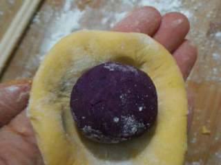 7、水晶南瓜饼,取约30g南瓜团，撮圆，放入紫薯球，包好，放入月饼磨具压出形状即可。（月饼磨具一定要摸一点油，防止沾，没磨具包好压扁就可以）。