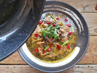 9、酸菜肥牛,另取一锅烧热油。将热油浇在干辣椒和香菜段上激发出辣椒和香菜的香味。