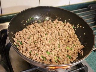 2、炸酱,加入红葱末﹐蒜末﹐姜末﹐跟肉一起炒香。再加入葱花拌炒。
