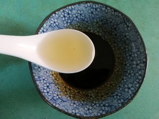 5、虾皇粉丝煲,现在来调料汁，准备一个小碗，倒入一汤匙酱油，一汤匙蚝油，一点点盐和白糖，最后放入两勺泡香菇的水