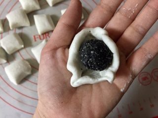 10、小萌狗黑芝麻汤圆,把小剂子揉圆按扁,包入冻硬的黑芝麻馅儿。