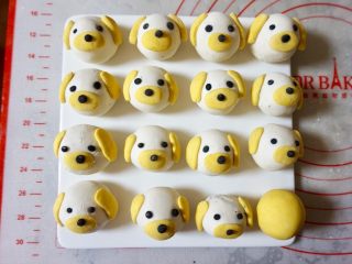 16、小萌狗黑芝麻汤圆,再用黑色粉团,搓出一个个的小圆点,做狗狗的眼睛和鼻子,沾水全部贴好。