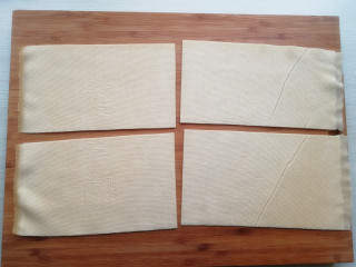 3、【豆皮金针菇卷】,将豆皮铺开,切成4份