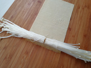 4、【豆皮金针菇卷】,取一张豆皮,平铺开,两边放上金针菇