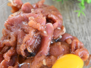 3、麻辣与热烫的刺激，征服你的味蕾，水煮肉片,打入一个鸡蛋，抓匀，倒入5g淀粉，再抓匀