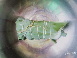 11、烤肉味粽子,左手把粽叶覆盖到右手的粽子上。再往下一折余下的粽叶，就包住了，左手别松手。捆绑好即可。