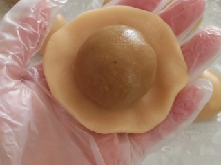 10、蛋黄莲蓉月饼,把月饼皮按扁，包入蛋黄莲蓉，收口朝下