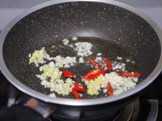 16、青椒炒猪腰,锅子清洗干净再次放入油，烧热后爆香姜蒜和小米辣