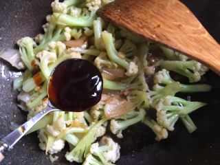 13、干锅花菜,加入一勺蚝油，一大汤勺开水，翻炒均匀，盖上锅盖，中小火焖一分钟左右