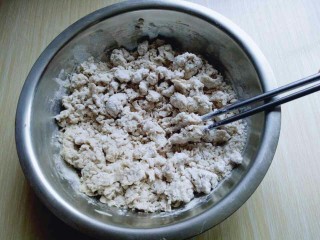 3、凉拌莜面鱼鱼,边倒开水边用筷子挑成絮状。