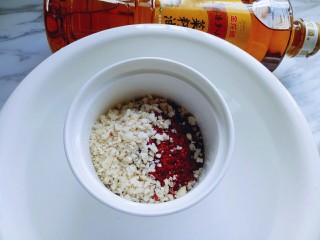 5、油泼辣子,将擀碎的花生加入辣椒粉器具里。