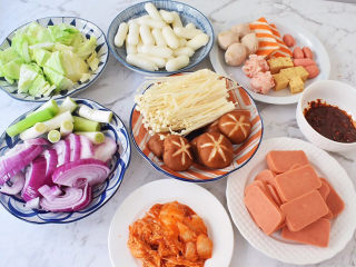 2、部队火锅,卷心菜洗净切成小块,洋葱洗净切成条状,大葱洗净切寸段,火腿肠切片,金针菇去根部洗净,香菇去蒂洗净,辣白菜切成小块