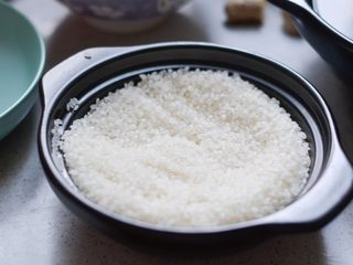 1、腊肠葱香煲仔饭,用砂锅量好一碗米，提前1小时泡发，避免夹生