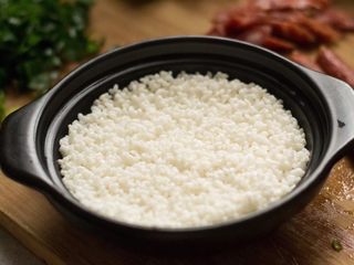 6、腊肠葱香煲仔饭,把米铺平，不要超过锅盖线