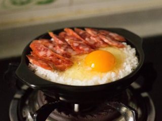 9、腊肠葱香煲仔饭,加入香肠，鸡蛋，焖5分钟。