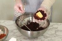 11、紫米芝士肉松饭团,在米饭中间放入肉松、芝麻、蛋黄酱和芝士片。如果是新手，一开始几个少包一点馅料，不然漏出来就很丑。