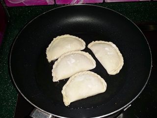 16、韭菜盒子,平底锅加热放少许芥花油，再放入韭菜盒子生坯