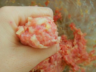 5、冬瓜新吃之不一样的冬瓜汆丸子,下面就是关键步骤挤丸子了，先用手抓起一些肉馅，用拇指拨弄一下靠近虎口处的肉馅，然后攥拳，虎口处就挤出来一个漂亮的小丸子了