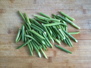 2、蒜苔炒腊肉,蒜苔处理,清洗好了之后(切蒜苔也是有窍门的哦)蒜台洗好平放在菜板上,刀倾斜与菜板形成30度的夹角,下刀切蒜苔,使蒜苔切面口更大更容易入味