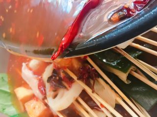 12、#辣味#串串香麻辣火锅,把蔬菜和串好的串儿码在酒精锅内，倒入煮好的辣汤。
