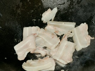 5、干锅茶树菇,锅中加少许油，将五花肉爆炒至微卷。