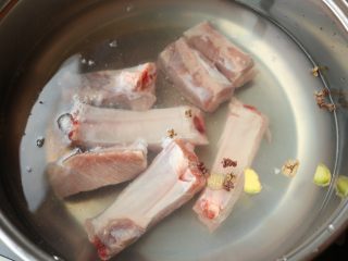 2、多味排骨,电磁炉，汤锅里加入水，排骨冷水下锅。加入姜片，葱段和花椒。